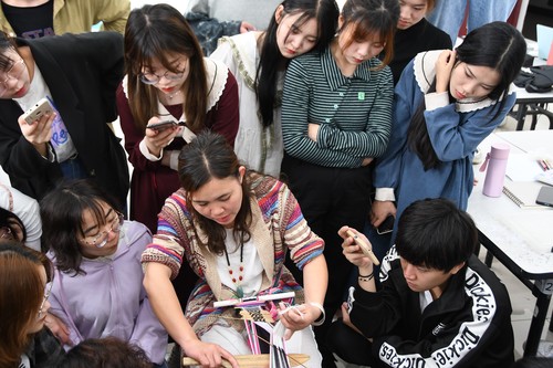 黄翠兰老师现场为学生们传授织锦技艺